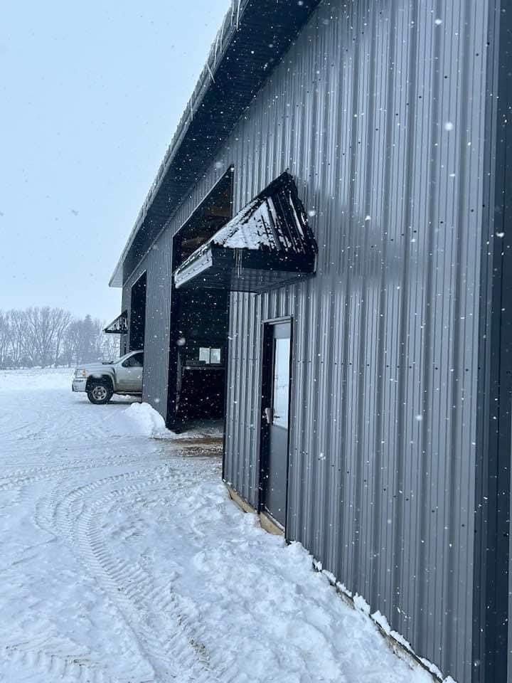 Grey and black farm shop with overhead doors built by Hoksbergen & De Stigter